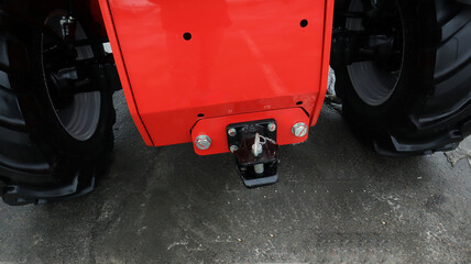 Towing device mounted on tractor showcasing robust coupling mechanism and high traction tires for...