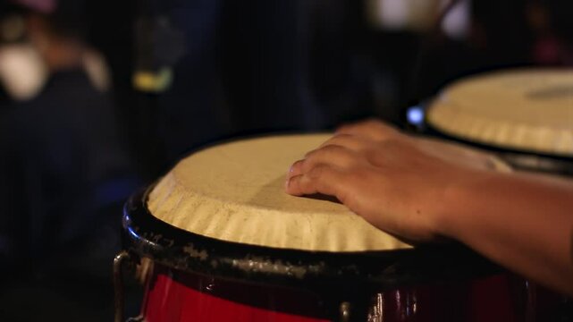 Close of man playing percussion instrument, conga, drum, atabaque in a numbers concert