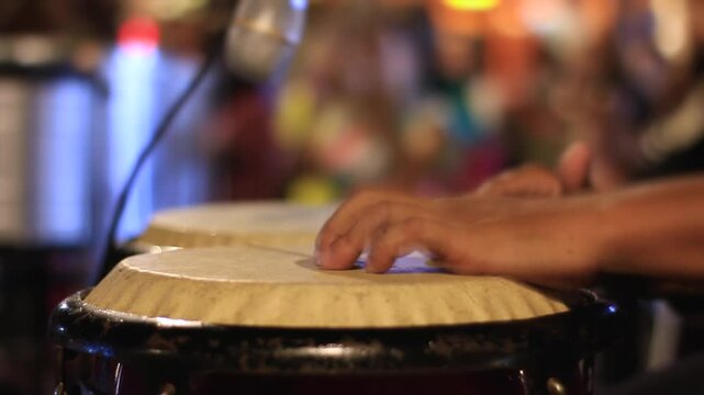 Close of man playing percussion instrument, conga, drum, atabaque in a numbers concert