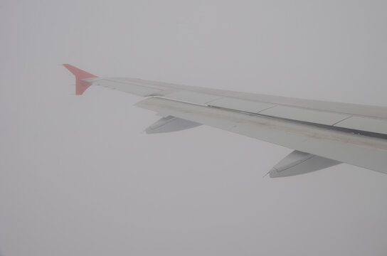 Wing of an airplane in the fog during take off. Nantes Atlantique Airport. Nantes. Loire-Atlantique department. Brittany. France.