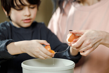 Mother and son are preparing a cherry cake together