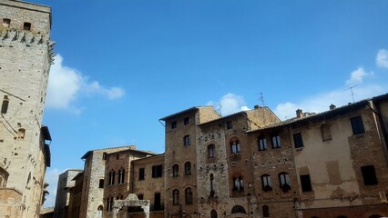 Fototapeta premium Medieval houses on a square in San Gimignano, Tuscany, Italy