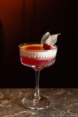 Red alcohol  cocktail with raspberry and leaves