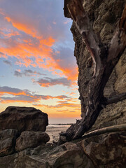 sunset on the coast of Nicaragua with bright orange clouds that we can see behind the cliff