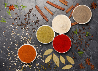 Spices in bowls: turmeric, paprika, cardamom, nutmeg, black and allspice.