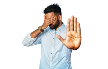 The person in the image is wearing a light blue button-up shirt and a wristwatch. He is covering his face with one hand while extending his other hand forward with an open palm.