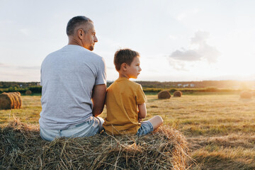 Father and son sharing a joyful moment in a sunset field, playing together. Happiness and family connection concept