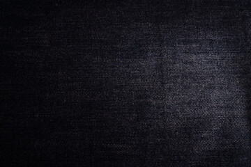 Background close-up of dark denim, showing its texture and rich indigo color, suitable for clothing...