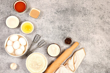 Kitchen background of food preparation with space for text. Culinary ingredients for making pie and bread, recipe with eggs, flour, sugar, honey, cinnamon, yeast and butter. Modern bakery concept,