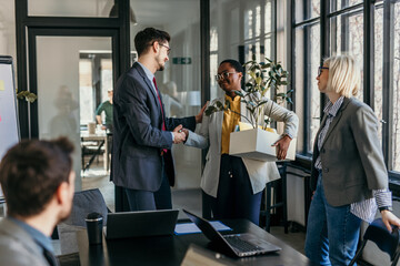 A group of coworkers is saying goodbye to an old colleague who is leaving the office. Concept of loosing job