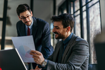 Focused business partners reviewing documents during a corporate meeting