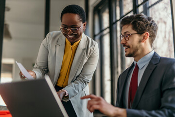 Professional discussion between two colleagues in a modern office setting