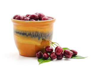 Red cherries in a pot and nearby.