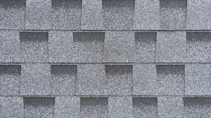 Grey and dark grey asphalt shingles with basalt chips. Geometric background of many rectangles.