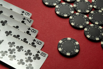The playing cards are a straight flush and black poker chips are scattered across the red felt table. The atmosphere suggests a casual and strategic night of gaming