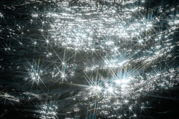 Sunlight reflects off flowing water, creating a dazzling starburst effect. The contrast between...
