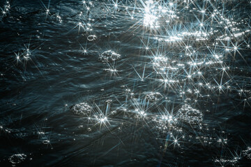 Sunlight reflects off flowing water, creating a dazzling starburst effect. The contrast between...