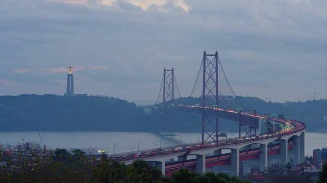 Bridge at sunset from Miradouro do Bairro do Alvito tourist viewpoint with Tagus river, traffic on 25th of April Bridge at sunset. Lisbon, Portugal. Timelapse