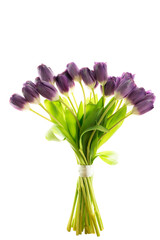 Elegant bouquet of purple tulips with fresh green leaves arranged for decoration or gifting in a bright setting