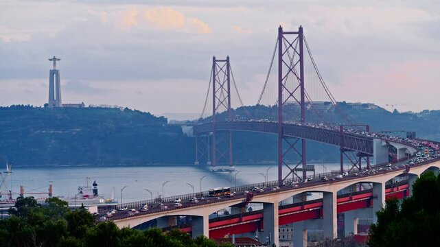 Bridge at sunset from Miradouro do Bairro do Alvito tourist viewpoint with Tagus river, traffic on 25th of April Bridge at sunset. Lisbon, Portugal