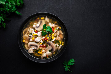 Spicy soup with chicken, mushrooms, corn, white beans, chili and cilantro. White background, top view