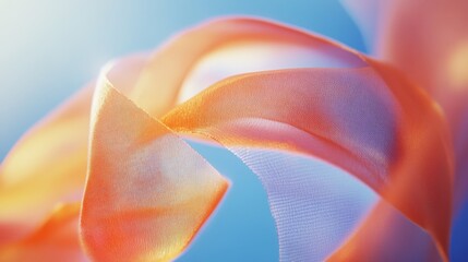Obraz premium Delicate orange fabric dances gracefully against a soft blue background in a swirl of light and texture.