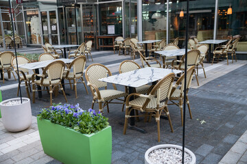 cozy empty street cafe outdoors. Tables, chairs and umbrellas.