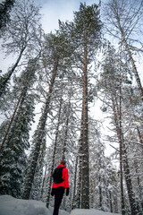 A girl in front of high trees in Lapland Finland