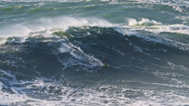 Surfer is riding big wave.Extremal big wave surfing. Nazare, Portugal