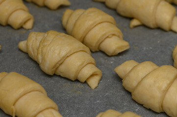 Warm buttery croissants resting on parchment, ready for the oven before a delightful morning delight