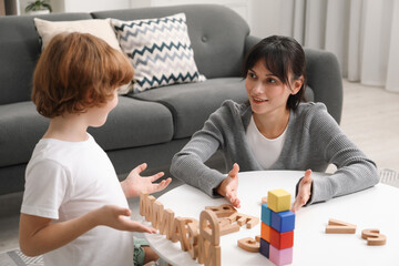 Psychologist evaluating boy's cognitive functions at table in office