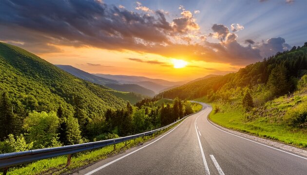 A winding asphalt highway stretching through lush green mountains under a dramatic sunset skay