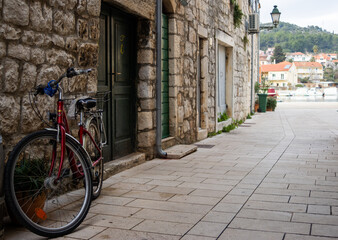 Bicycle leaning against an old stone house. Promenade in the background