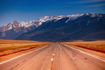 Beautiful autumn road with snow-covered peaks mountains North Chuya mountain ridge in Altai, Siberia, Russia