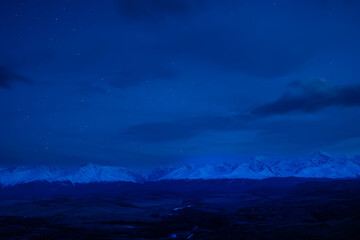 Snow-capped peaks North-Chuya mountain ridge under twilight sky in Altai, Siberia