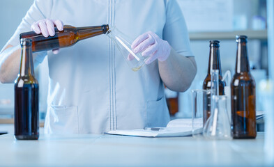 Brewery worker pouring beer in lab setting