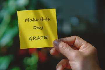 Colored paper note with masking tape with motivational phrases, hand holds a post it with blurred background, copy space.