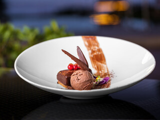Elegant chocolate brownie with ice cream plated in a white dish