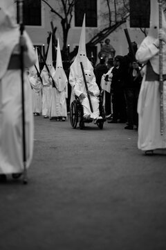 Fototapeta Traditional Holy Week Procession with Hooded Penitent in a Wheelchair