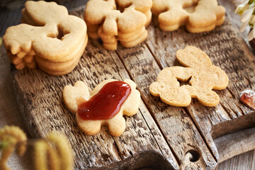 Filling Linzer Easter cookies in the shape of bunny with strawberry marmalade