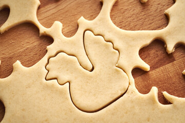 Cutting out hen shapes from raw pastry dough - making homemade Linzer Easter cookies