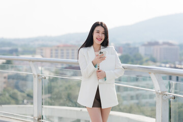 Fototapeta premium Smiling Businesswoman with Phone on Balcony