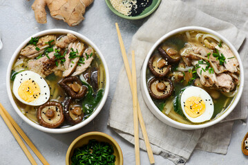 Ramen soup with chicken, shiitake mushrooms, spinach and egg in bowls .style hugge
