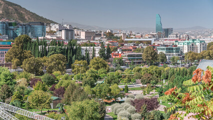 Aerial timelapse of Rike Park, a modern urban park in Tbilisi's Old Town with green trees and lawns. The Bridge of Peace in the background. Georgia © HyperlapsePro