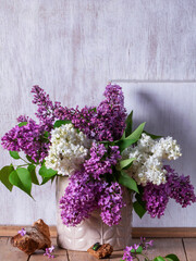 Bouquet of multi-colored lilacs, wood chips and insects on a light background.