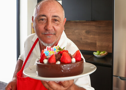 Senior man presents chocolate cake for his 50th birthday - Powered by Adobe