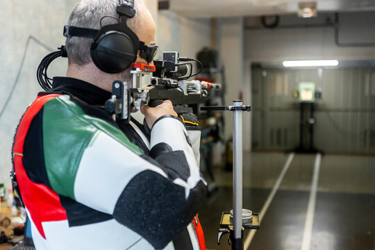 Blind Paralympic Shooter Aiming in Indoor Training Range
