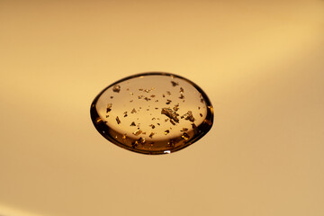 Close-up view of anti-aging serum with golden flakes.