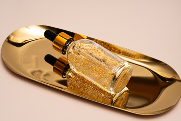 Luxurious golden anti-aging face serum on a glossy tray