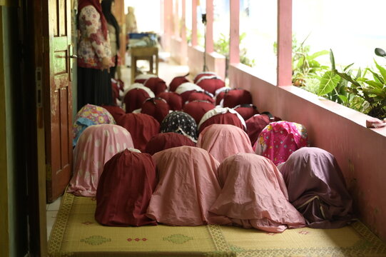 Back view of unrecognizable women praying in a row